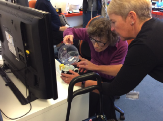 Rachel at SARC demonstrating a liquid level indicator to someone with sight loss